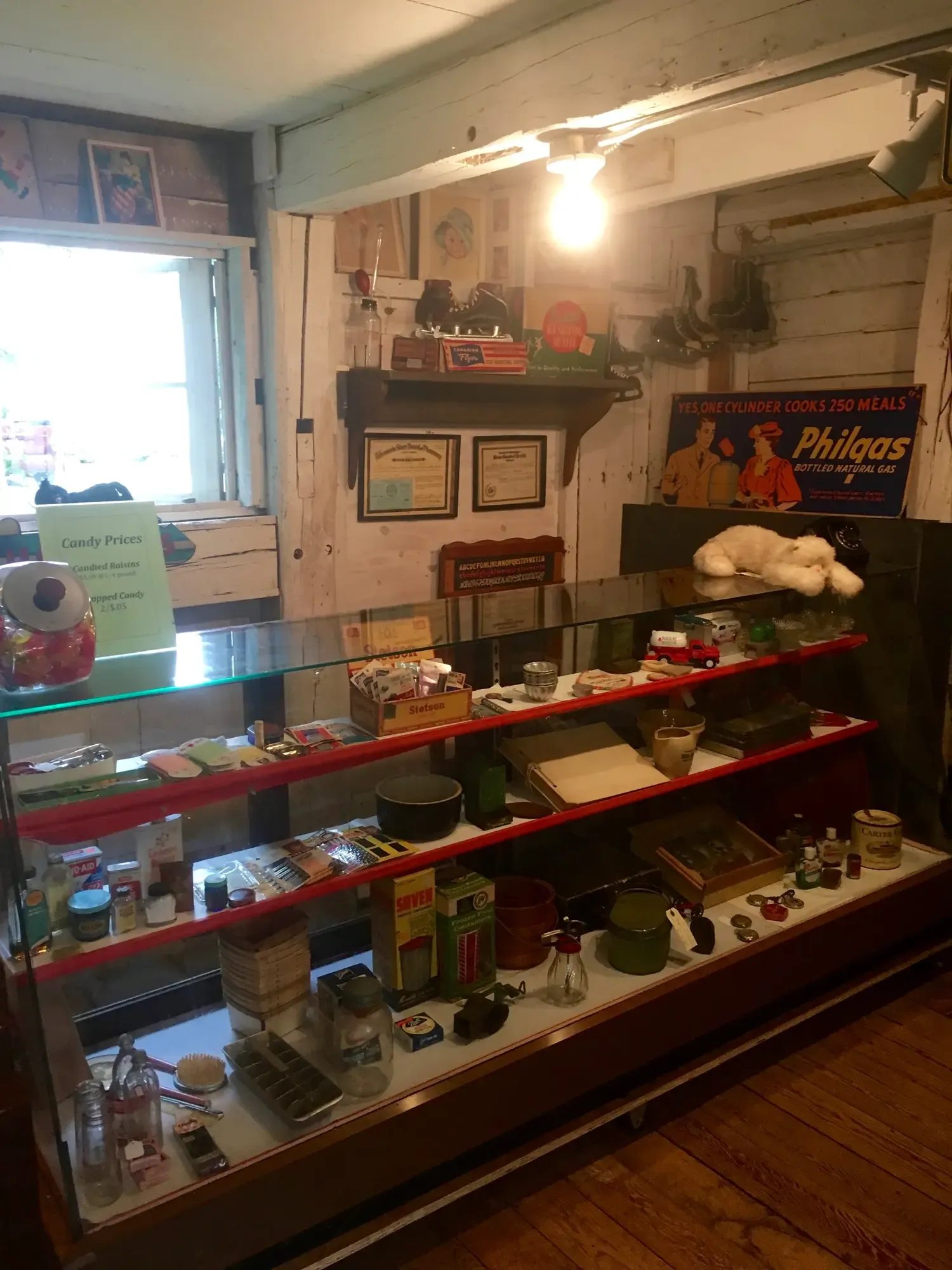 The general-store display case stocked with vintage wares, penny candy, and a Philgas sign